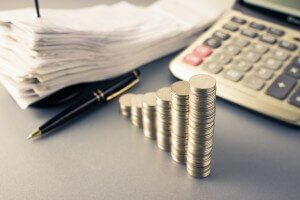 Coins heap stair as growing graph symbol on finance working desk