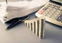 Coins heap stair as growing graph symbol on finance working desk